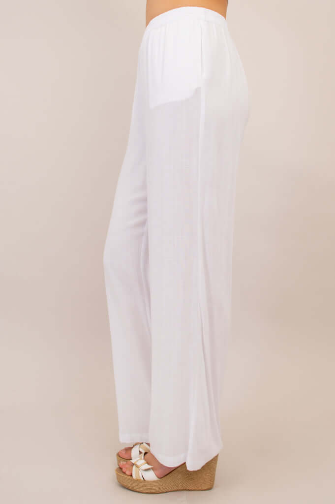 Side view of white linen-bamboo pants highlighting straight drape