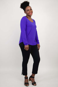 Side angle of woman in a purple long sleeve top paired with black pants
