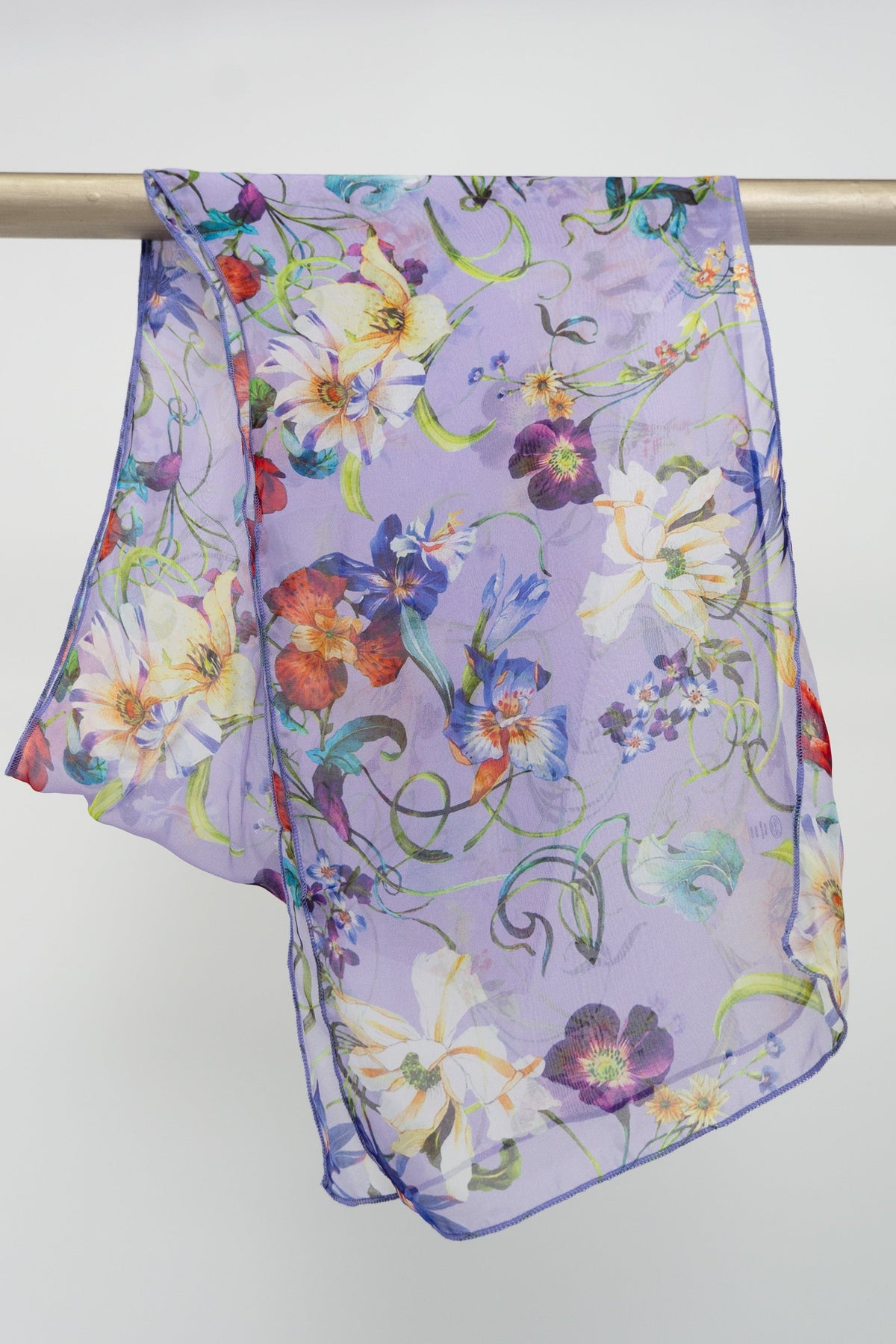 A purple silk scarf with a floral pattern displayed on a rod, front view