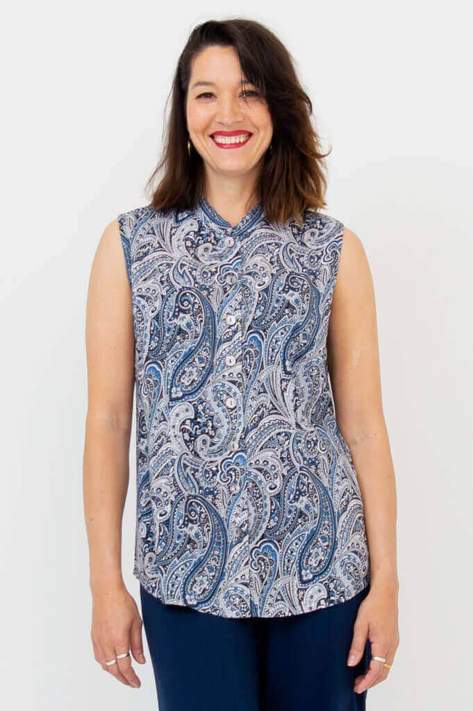 Woman wearing a sleeveless blue paisley button-down blouse with Mandarin collar