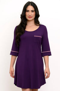 Woman wearing a purple dress with pink trim on a white background