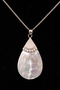 Close-up of sterling silver necklace with teardrop pendant on black background