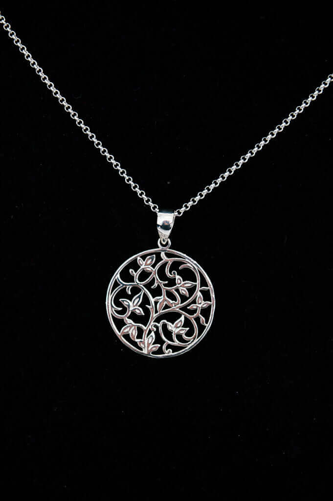 Sterling silver necklace with circular filigree vine pendant on black background