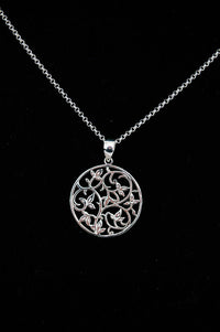 Sterling silver necklace with circular filigree vine pendant on black background