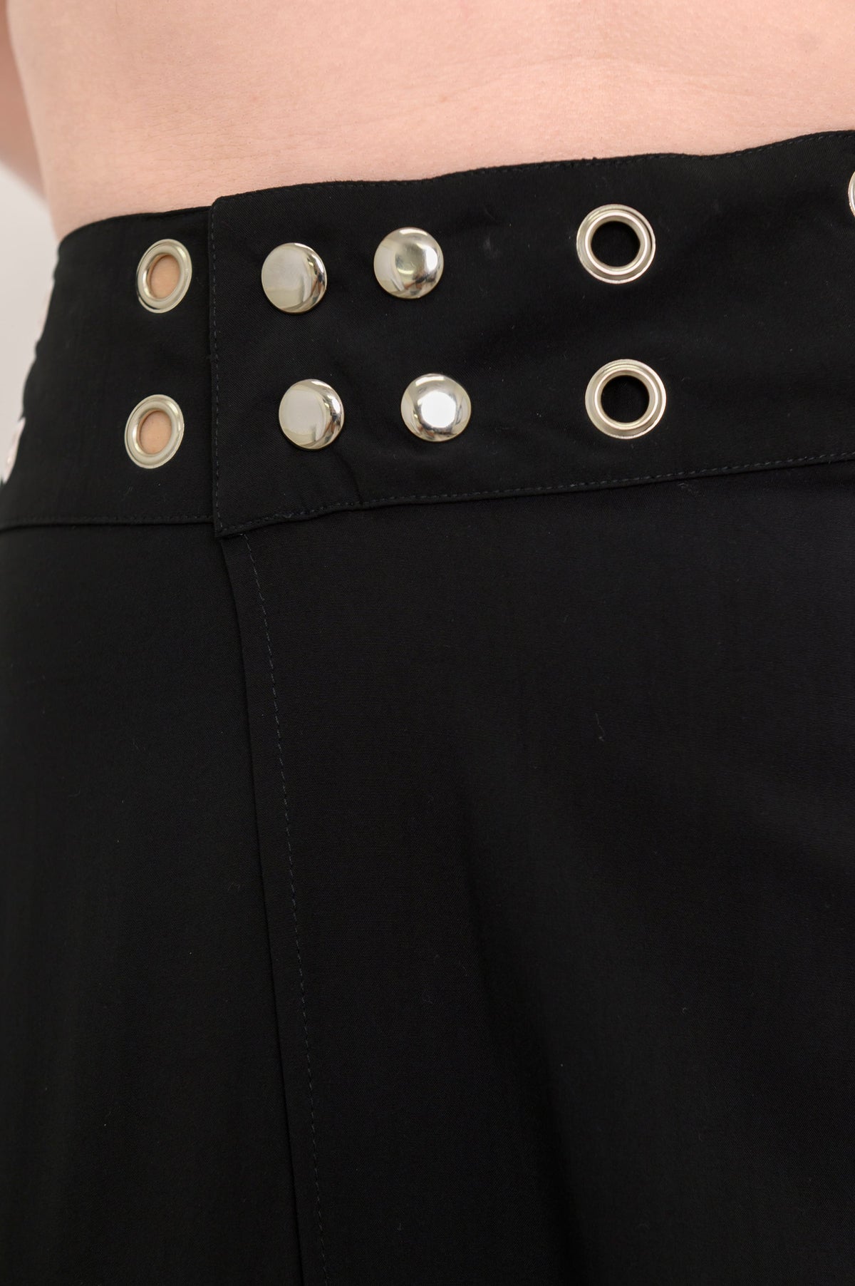 Close up of black skirt with grommet details at the waist