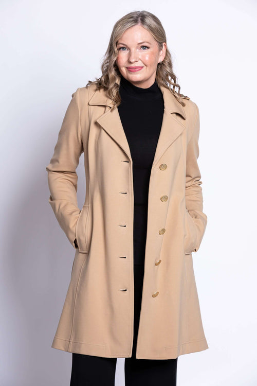 Woman wearing a tan modal trench jacket with button closure and notched collar