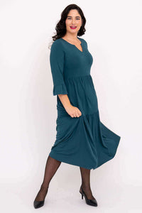 Model in motion wearing teal Bernadette Long Dress showing flowy fabric