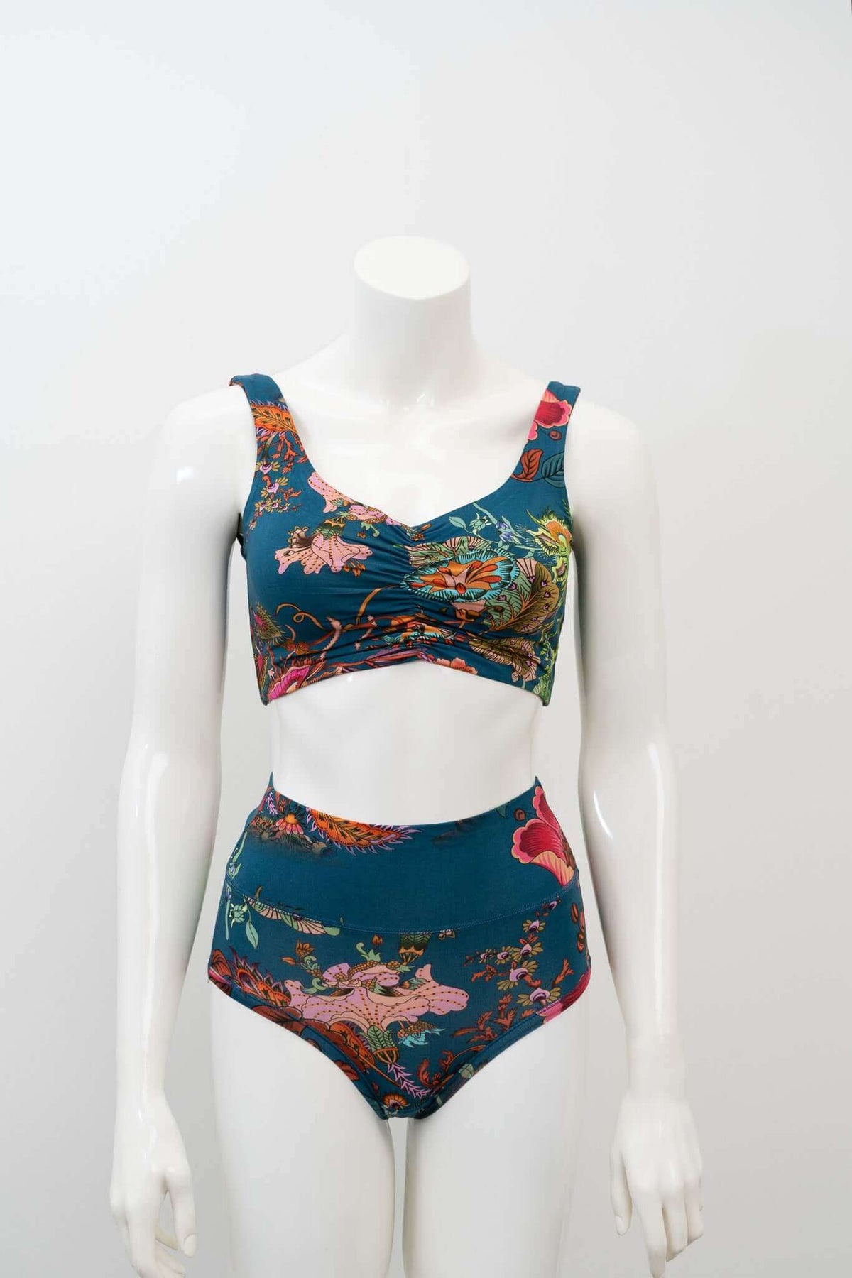 Teal floral crop top and high-waisted bottoms displayed on a mannequin, front view