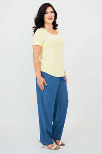 Side angle of model wearing Tessa Tee in butter yellow and blue pants