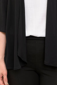 Close-up of the black Toucan Jacket in wrinkle-resistant rayon, layered over a white top to show the open-front drape.