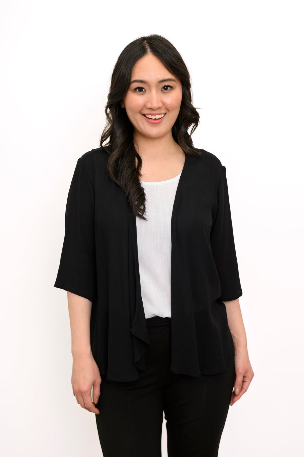 Front view of a woman wearing the Toucan Jacket in black wrinkle-resistant rayon, featuring 3/4 sleeves and an open, flowy style.