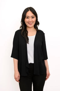 Front view of a woman wearing the Toucan Jacket in black wrinkle-resistant rayon, featuring 3/4 sleeves and an open, flowy style.