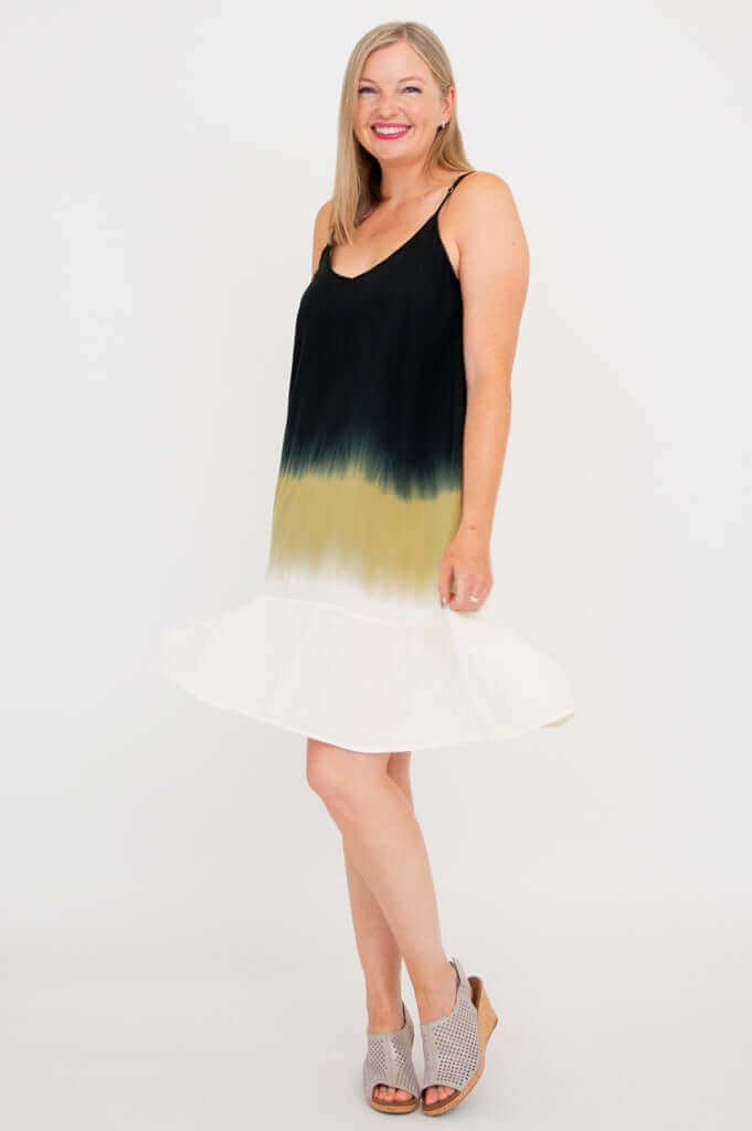 Woman twirling in ombre dress showcasing flounce hem and adjustable straps