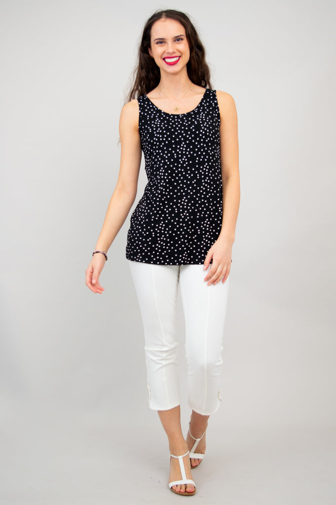Casual women's black polka dot sleeveless top with a round neckline and relaxed hip-length fit paired with white pants