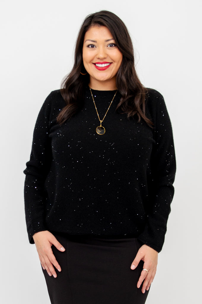Close up portrait of a smiling woman wearing a sparkly black wool cashmere scoop neck sweater.