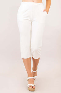 Walking pose in white Susan Capri pants and wedge sandals, focus on comfort fit