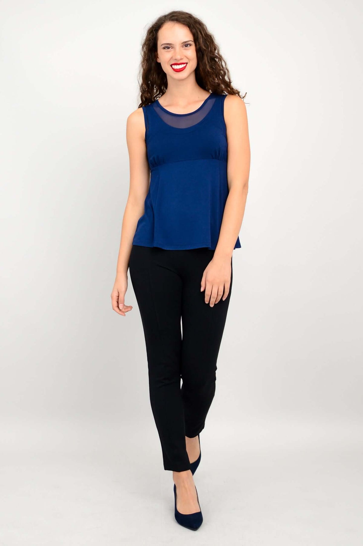 Woman walking in navy bamboo tank top with mesh neckline and black pants