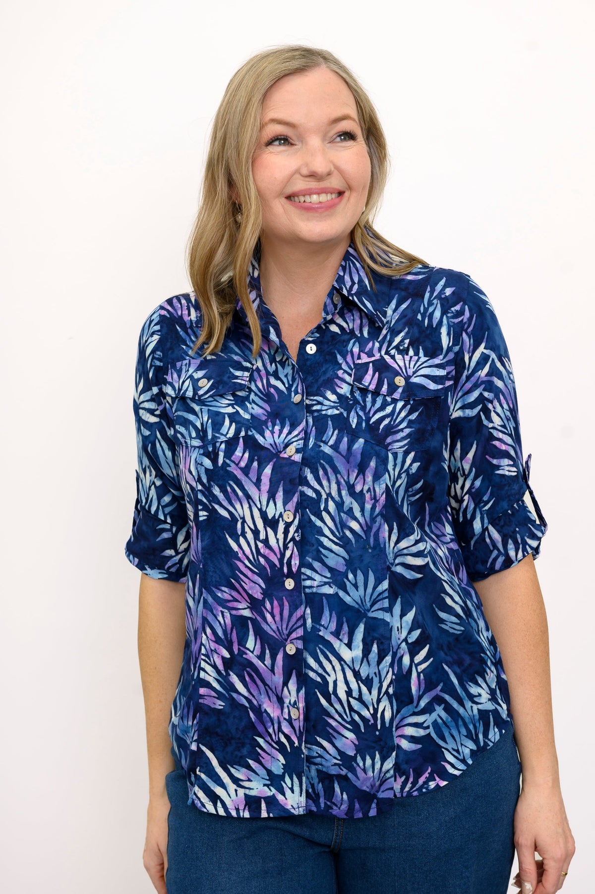 Front view of woman wearing a blue floral patterned blouse and jeans