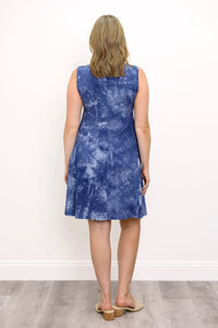Back view woman wearing sleeveless blue tie dye short dress and sandals, relaxed posture