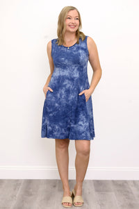 Front view woman with hands in pockets of her blue printed knee-length dress