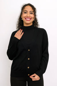 Close up front view of a woman wearing a black 100% merino wool deep v-neck cardigan sweater.
