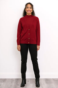 Front view of a woman wearing a dark red merino wool button down cardigan layered over black pants.