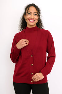 Close up front view of a woman wearing a burgundy 100% merino wool deep v-neck cardigan sweater.