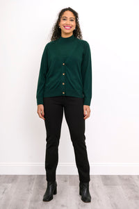 Full length shot of a woman in a deep green fine knit wool cardigan sweater styled with black boots.