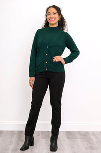 Full length view of a woman wearing a deep forest green merino wool v-neck cardigan and black pants.