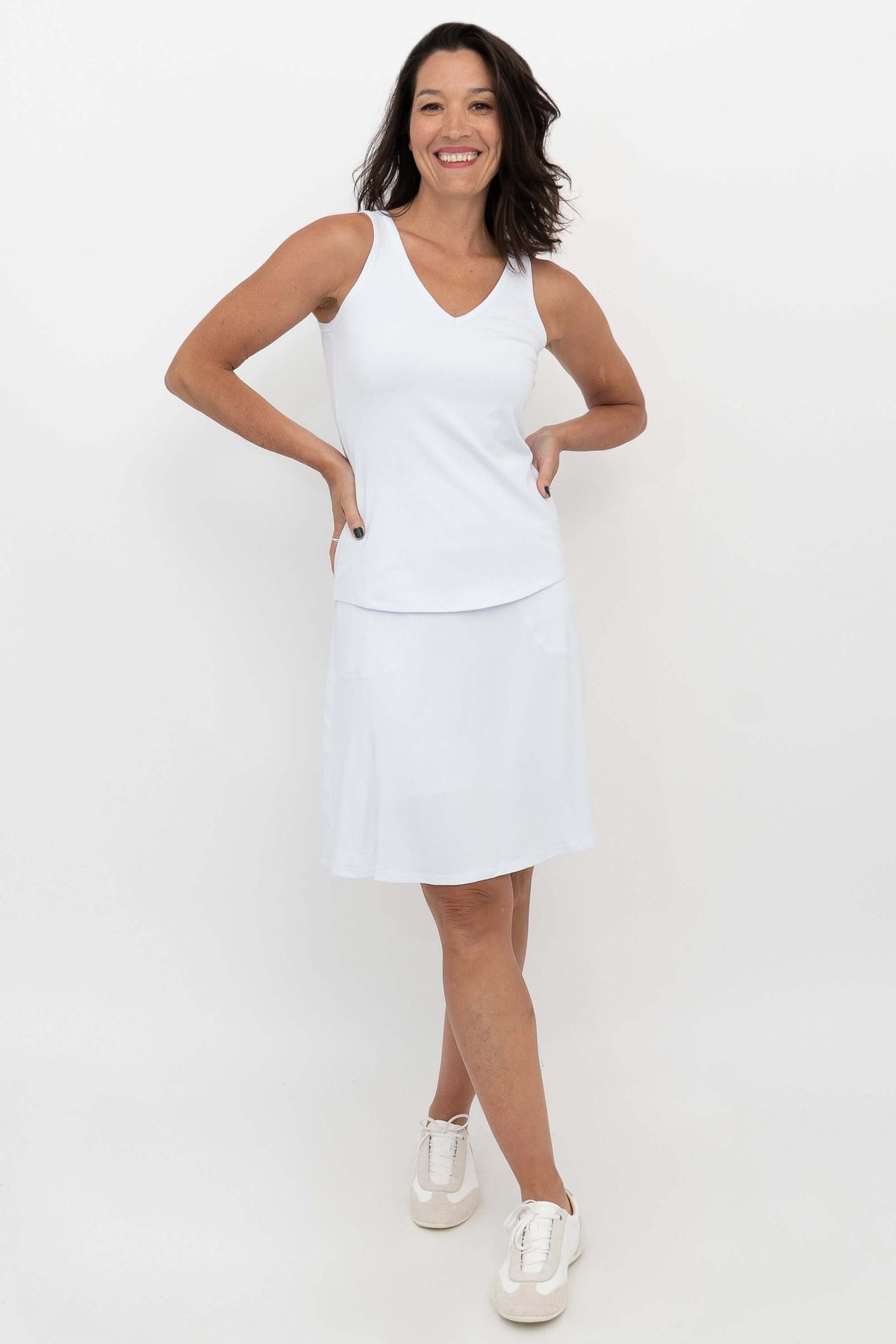Woman posing in white Magna Skort and tank top, hands on hips