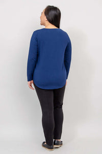 Woman in navy blue long sleeve top, back view