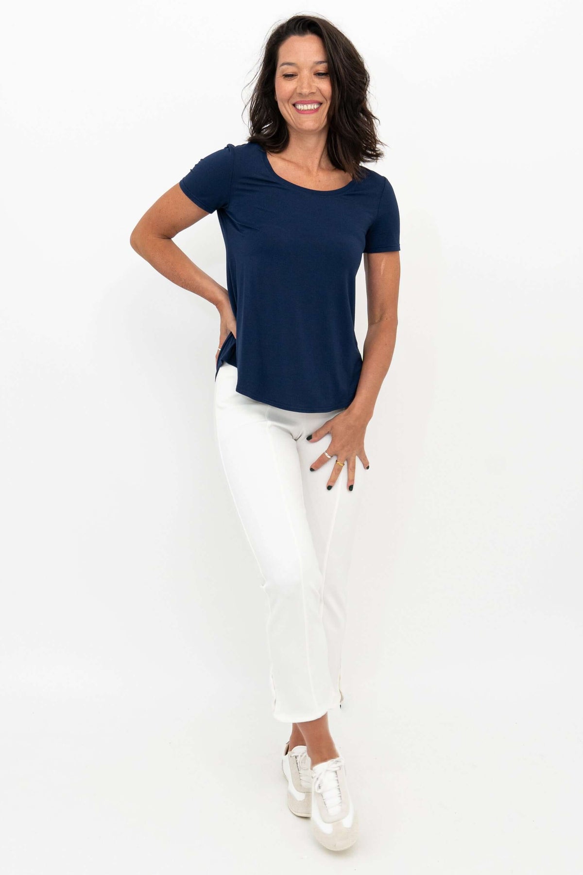 Woman in white Nadine crop pants and navy tee, relaxed pose