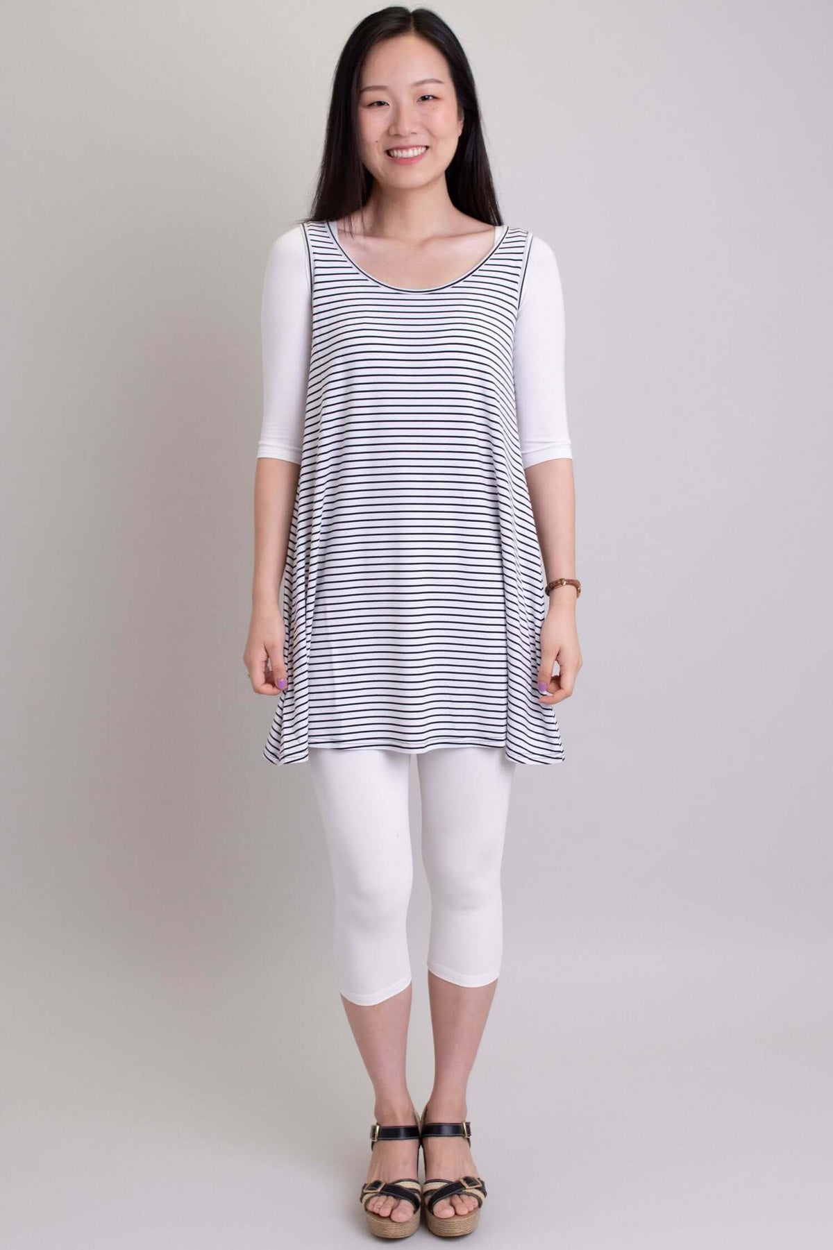 Woman layering white Instant Sleeve bamboo bolero under striped tunic and white capris