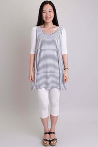 Woman layering white Instant Sleeve bamboo bolero under striped tunic and white capris
