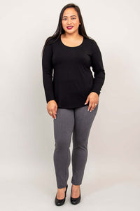 Woman modeling black long sleeve top and gray pants, full body front view