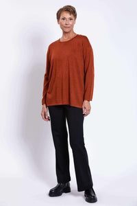 Woman modeling rust Merino sweater with relaxed boxy silhouette