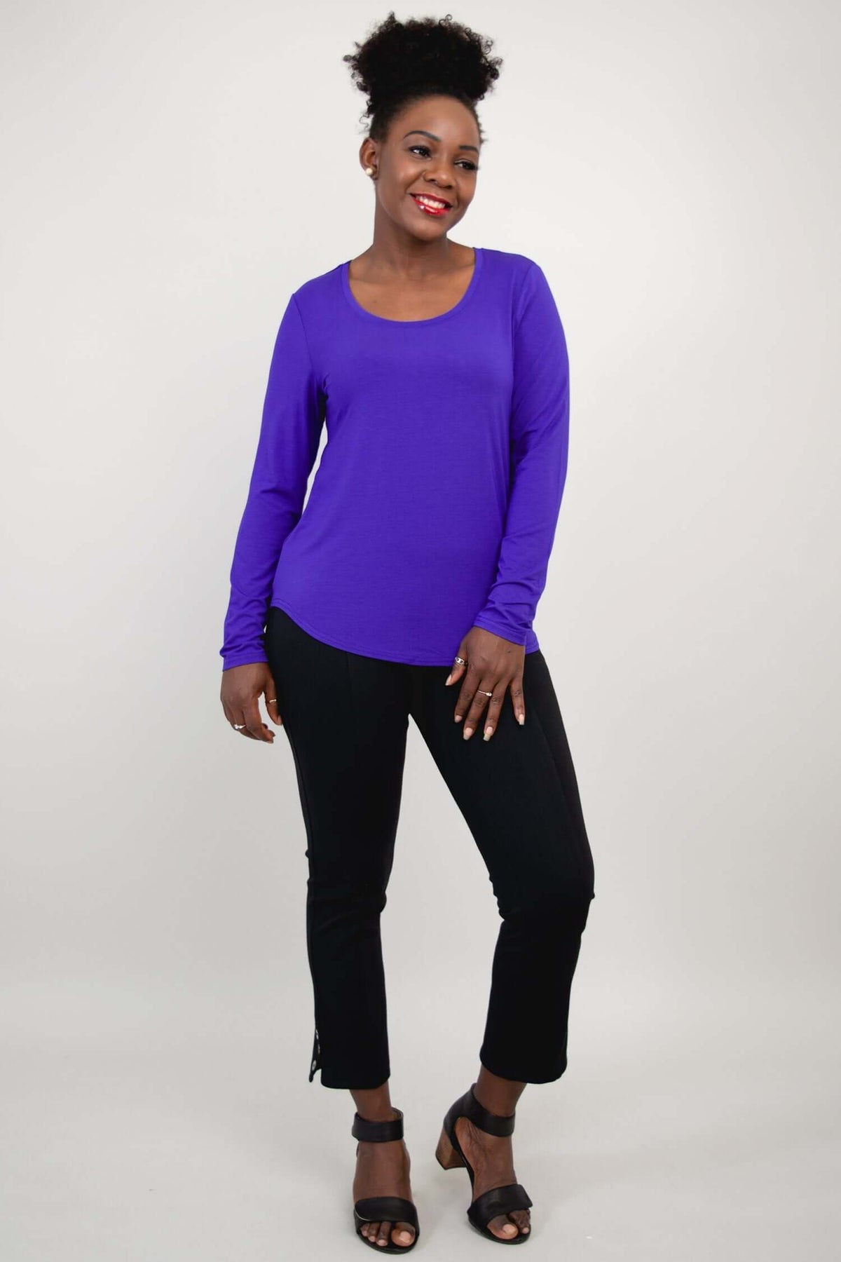 Woman posing in purple bamboo long sleeve top and black cropped pants