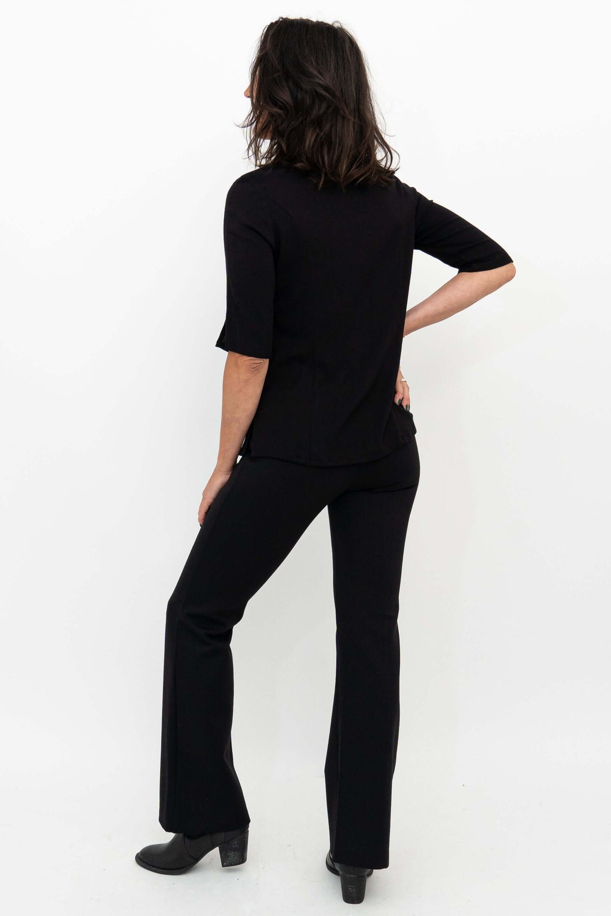 Woman showing back of Daya Luxe Modal Pants in black paired with top
