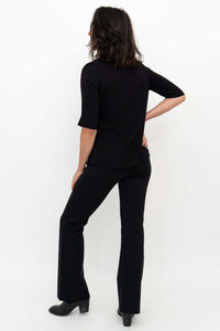 Woman showing back of Daya Luxe Modal Pants in black paired with top
