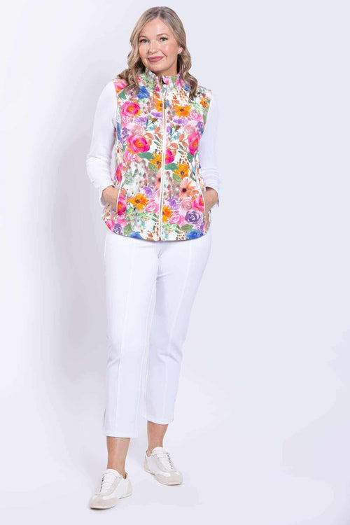 Full body view of woman in Hartford Pink Print Vest, white long sleeve top, and white pants