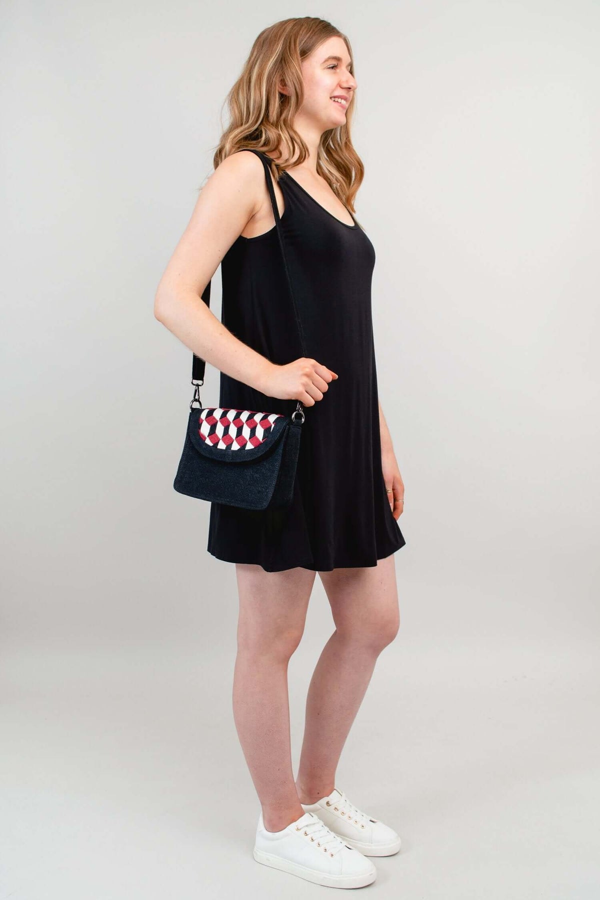 Woman wearing black geometric crossbody bag with long strap