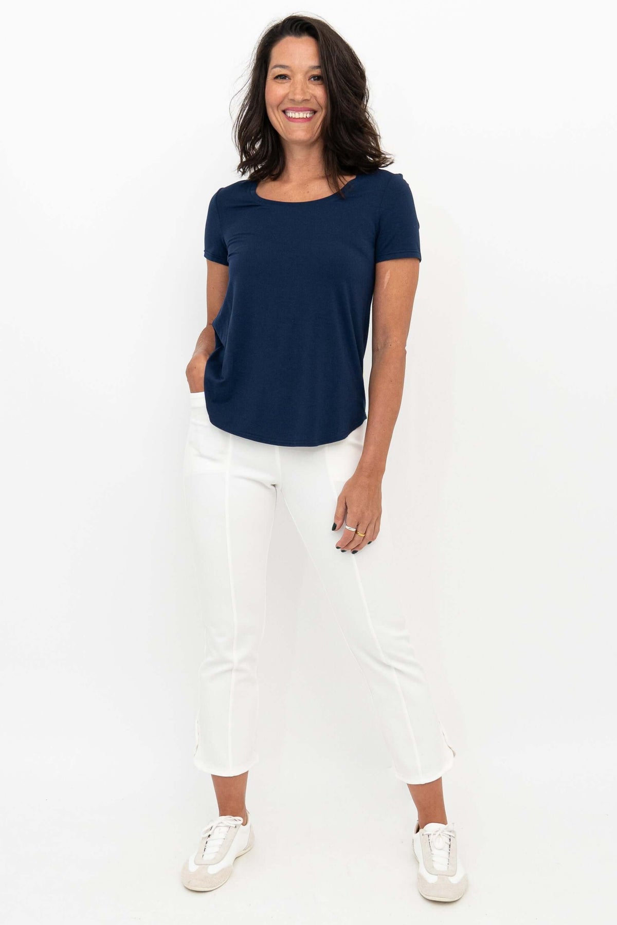 Woman wearing white Nadine crop pants and navy tee, front view