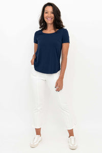 Woman wearing white Nadine crop pants and navy tee, front view