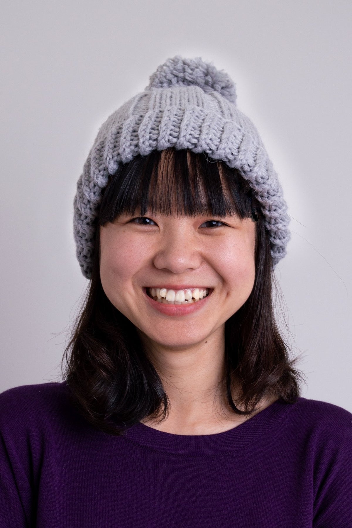 Women's grey knit toque wool hat with pompom.