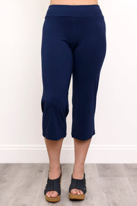 Close up front view of woman wearing dark blue capri pants and navy sandals