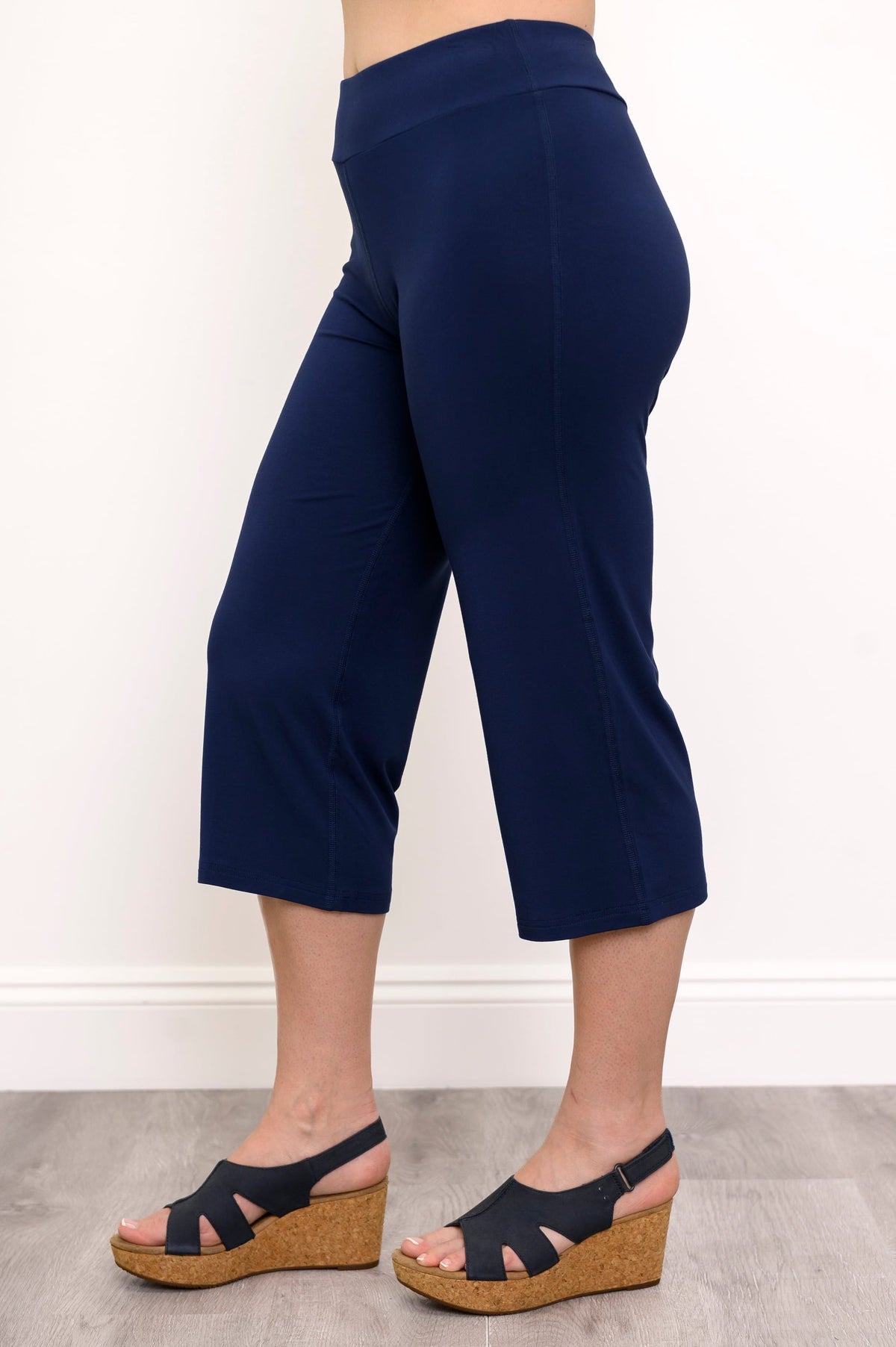 Side view of woman wearing indigo colored cropped pants and wedge sandals